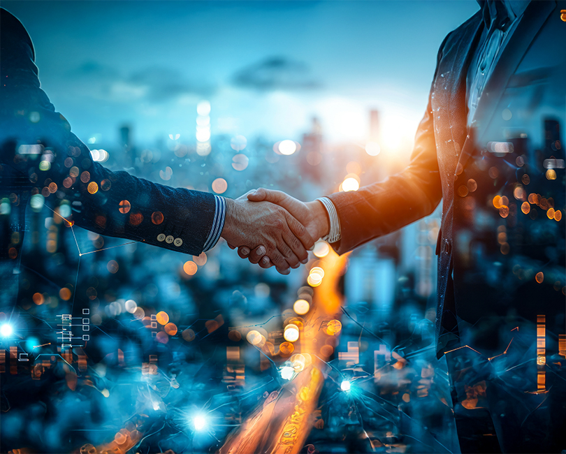 Two people shaking hands against a backdrop of a city skyline and blurred lights. The image conveys a sense of business partnership or agreement, with a futuristic overlay of digital elements and a warm glow from the sunset.