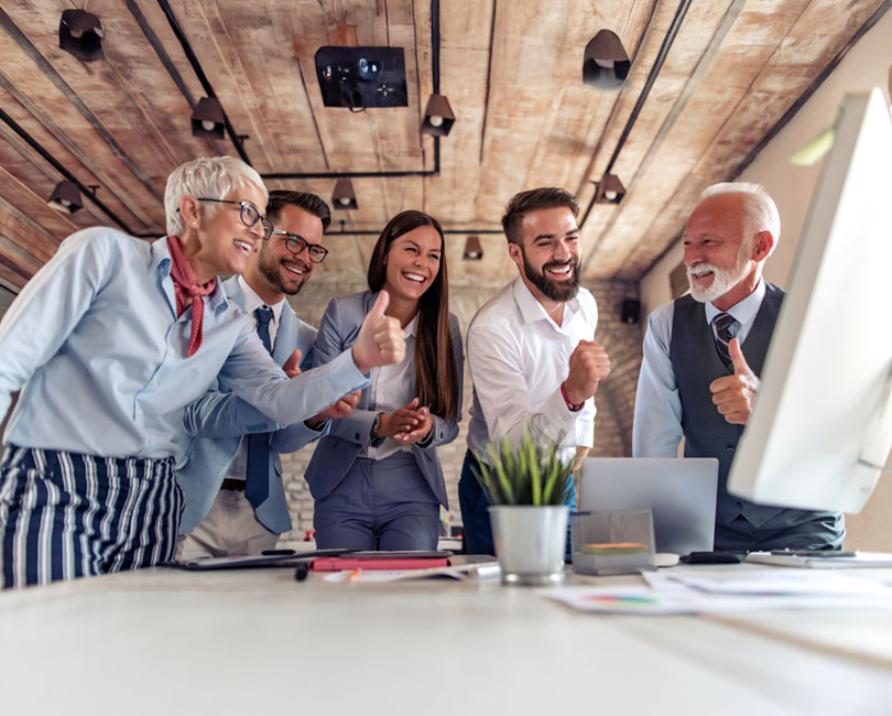 A professional image of a diverse group of people (representing different roles - Principal, Project Manager, Accountant) engaged in a collaborative discussion around a computer screen suggesting active interaction and hands-on learning.